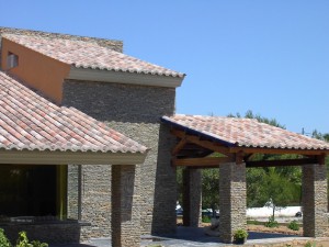 fachada de piedra y la cubierta inclinada con tejas cerámicas Celler® 50×21 en acabado Centenaria® Tierra